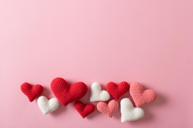 Background of knitted hearts on a light pink background for Valentine's Day