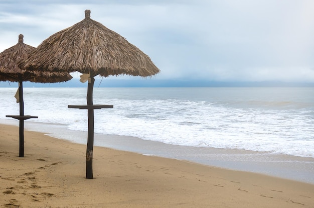 Background landscape with umbrella of palm leaves on the beach