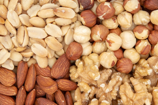 background of mixed nuts - hazelnuts, walnuts, almonds, pine nuts