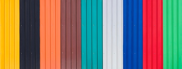 Background of multicolored corrugated metal sheets with polymer coating in panoramic view