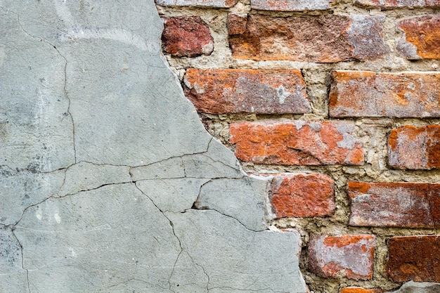 Background of old vintage brick wall with concreteWeathered texture of racked concrete vintage brick wall background