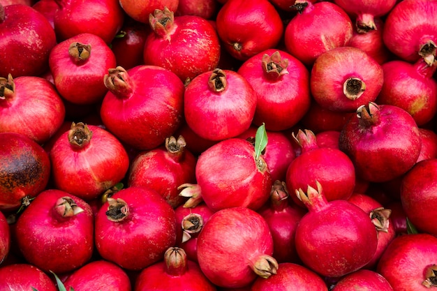 Background pattern of red ripe pomegranates in dark colors