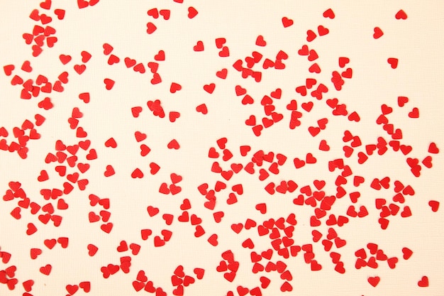 Background of small red hearts scattered on the yellow background