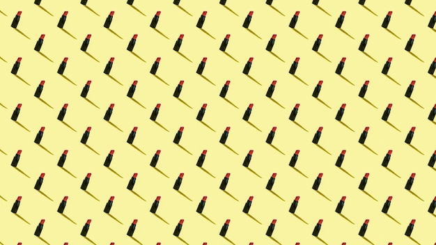 Background of small tubes of lipstick on a yellow background