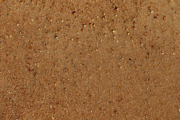 Background smooth surface of wet brown sea sand with texture and pattern copy space