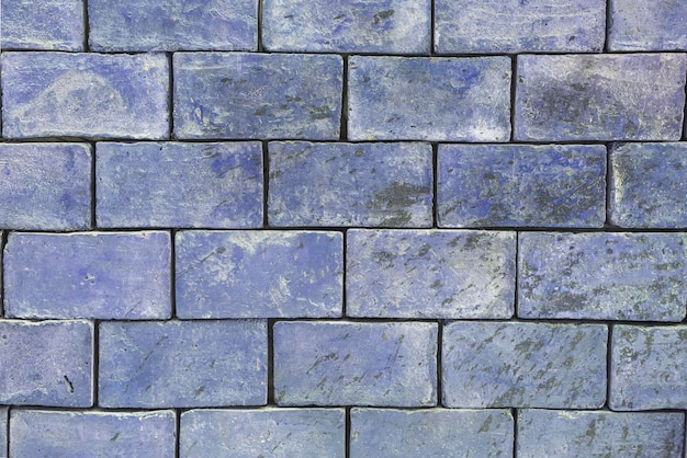 The background texture of a brick wall is light blue purple shades are large blocks