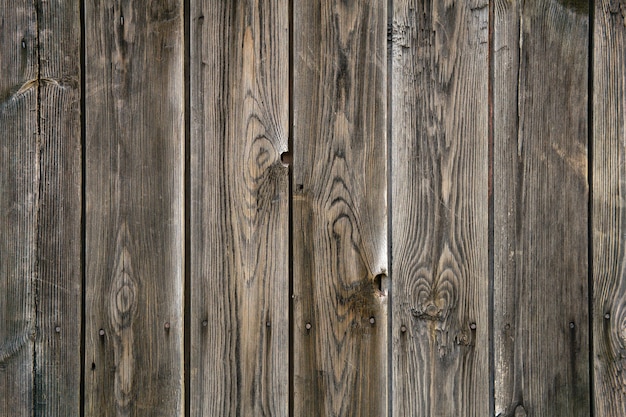 Background, texture - old plank fence of rough unpainted boards