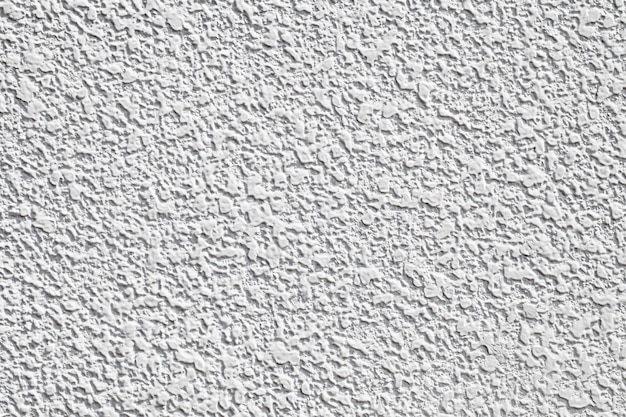 Background the wall is white plastered with drops of white mortar uniform texture