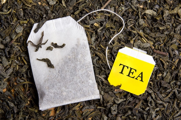 Photo background with dried black tea and paper tea bag