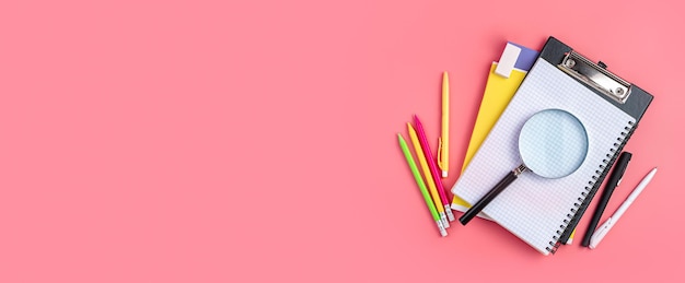 Background with school supplies on a pink background