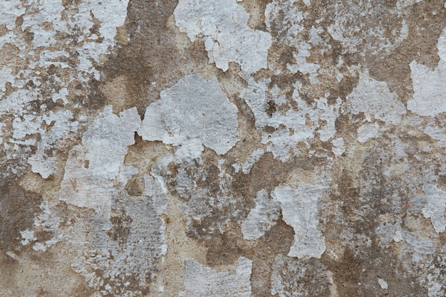 Background with wall texture with peeling old white paint.