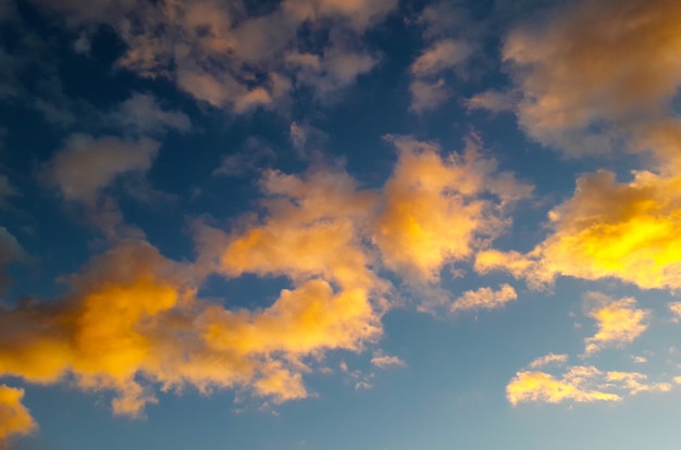 background with yellow and orange clouds over clear blue sky