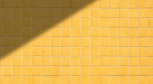 Background of yellow square tile wall pattern with light and shadow on surface in wide screen view