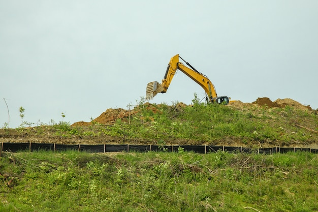 The backhoe was digging soil on top mountain in USA.