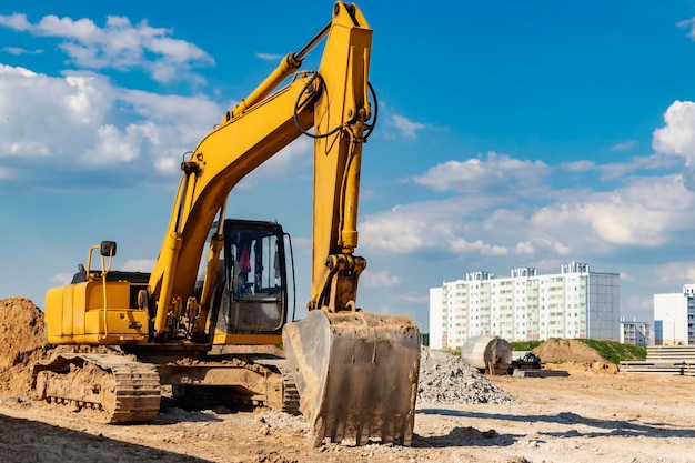 Backlit excavator on an industrial site against the background of the evening sky Construction machinery for earthworks