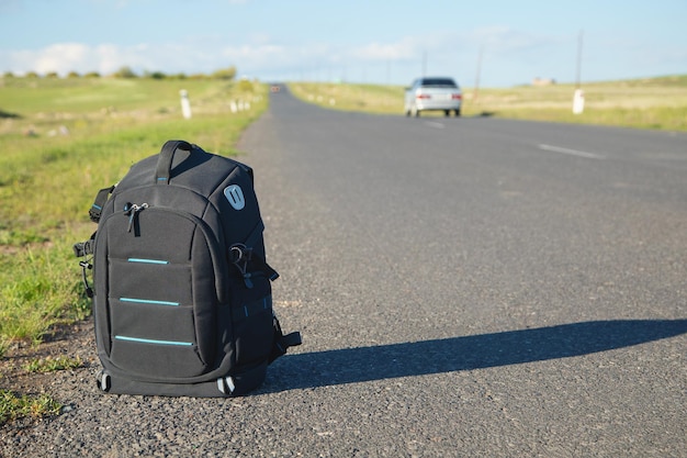 Backpack on asphalt road Adventure and travel