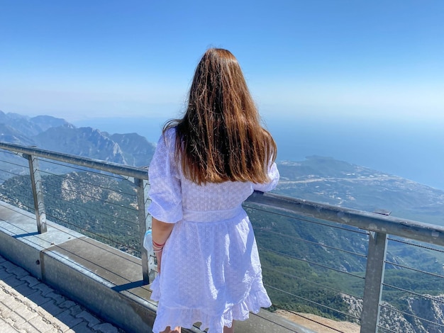 Backpack travel girl stay back to camera on hotel balcony observation deck place with picturesque