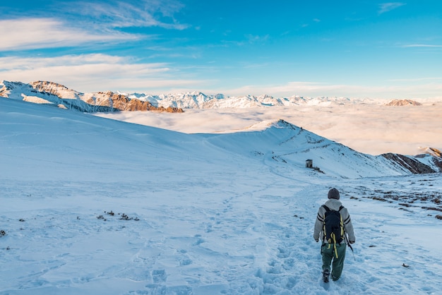 Backpacker hiking on snow on the Alps. 