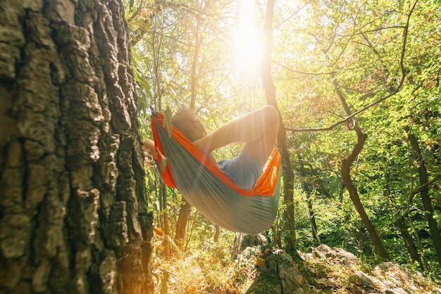 Photo backpacker relaxing in the hammock in the forest