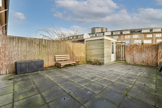 A backyard with a tiled floor and a fence made of bamboo at a cozy house