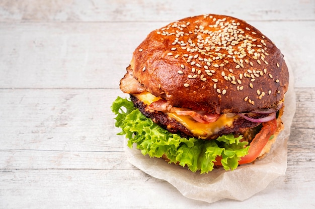 Bacon cheeseburger on a white wooden table