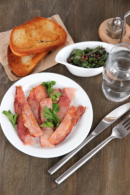 Bacon on plates on wooden table