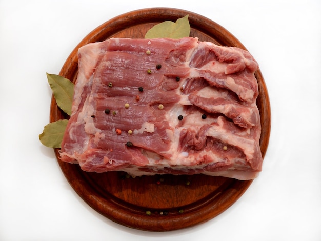 Bacon pork on a wooden board piece of raw meat isolated on a white background