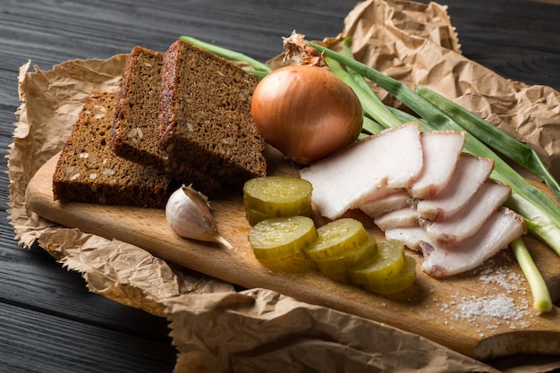 Bacon, rye bread on a wooden board