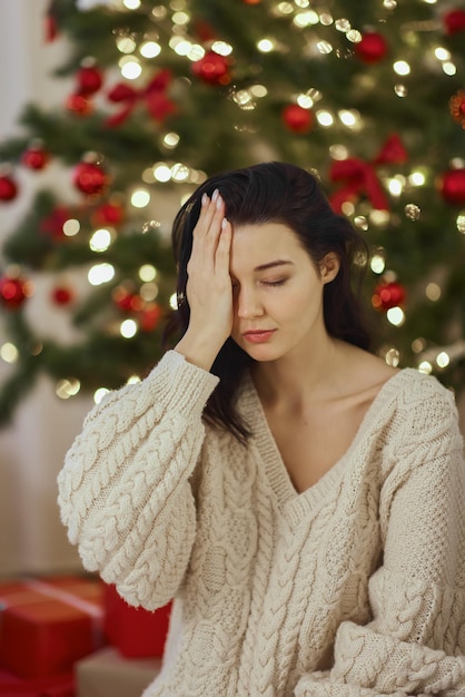 Bad christmas gift  disappointed and unhappy woman during winter holidays indoors at home