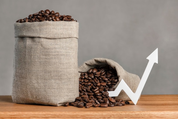 A bag of coffee beans and a chart arrow pointing up the cost of coffee in the markets of the world t