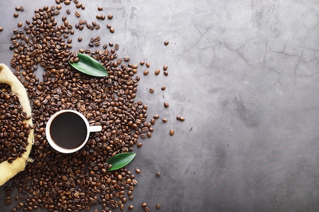 Bag of coffee. Coffee beans roasted on the table. Coffee beans with green leaves for cooking.