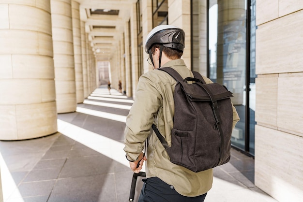 The bag is a backpack on the back of a man with a rear view and a helmet