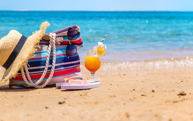 Bag and things for relaxing on the sea beach. Selective focus. Nature.