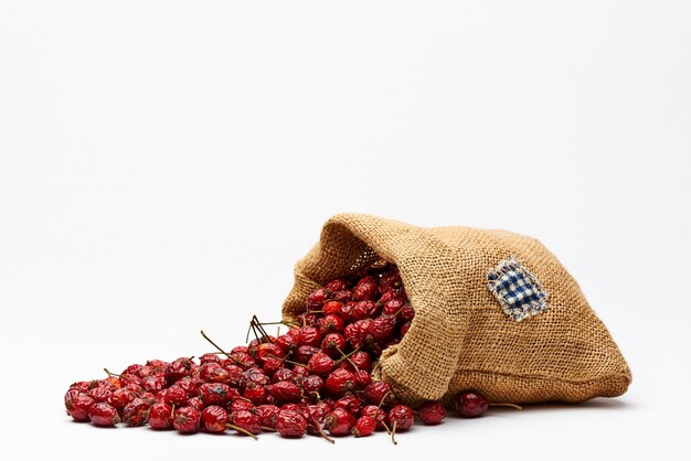 Bag with rose hips on white