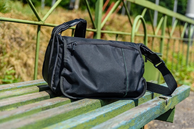 Bag on wooden bench at a railroad station at countryside