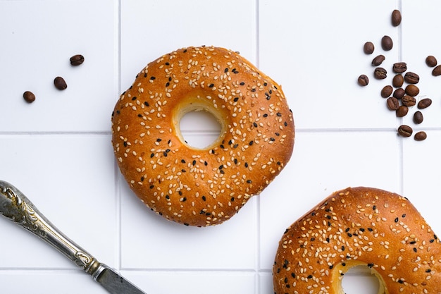 Bagel Freshly Baked set on white ceramic squared tile table background top view flat lay