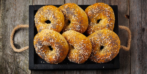 Bagels in a ceramic old bowl with a textile napkin on a light stone or concrete background. Selective focus. Top view. Copy space. Square image.