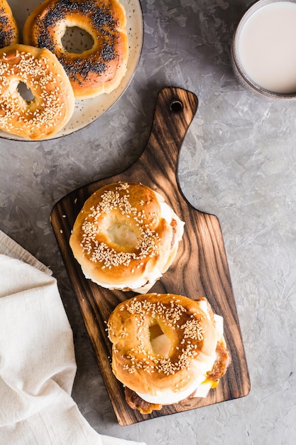 Bagels sandwiches with cheese fried meat and poached egg Homemade fast food Top and vertical view