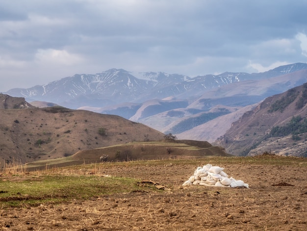 Bags of fertilizer on the field. Mountain farming.