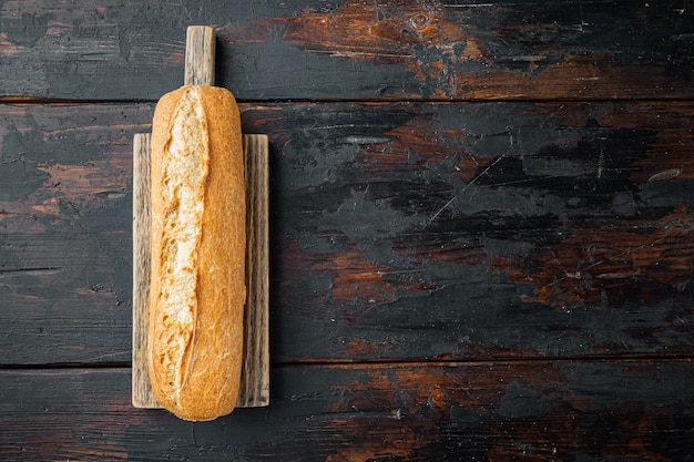 Photo baguette bread, on old dark  wooden table table, top view flat lay