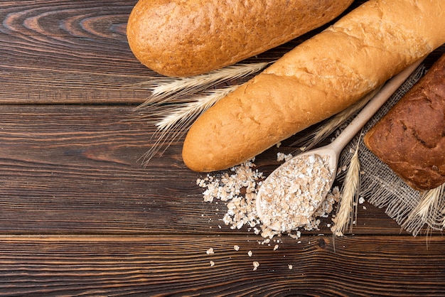 Baguette and wheat on table