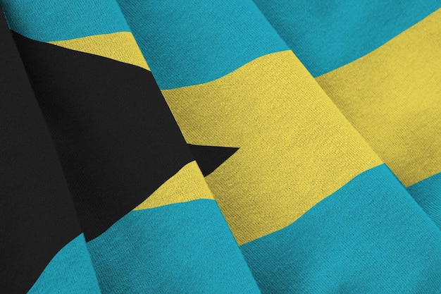 Bahamas flag with big folds waving close up under the studio light indoors The official symbols and colors in banner