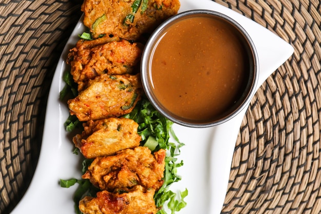 Bahrain kebab with sauce served in dish isolated on red mat top view on table arabic food