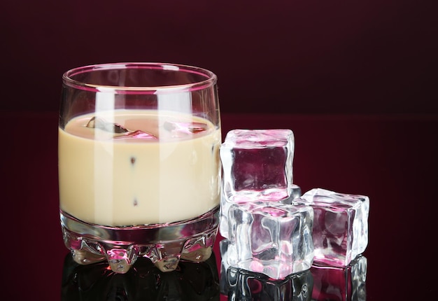 Baileys liqueur in glass on pink background