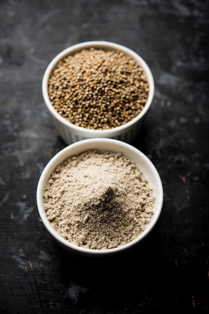 Bajra, pearl millet or sorghum grains with it's flour or powder in a bowl, selective focus