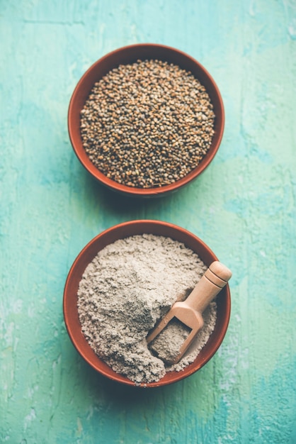 Bajra, pearl millet or sorghum grains with it's flour or powder in a bowl, selective focus