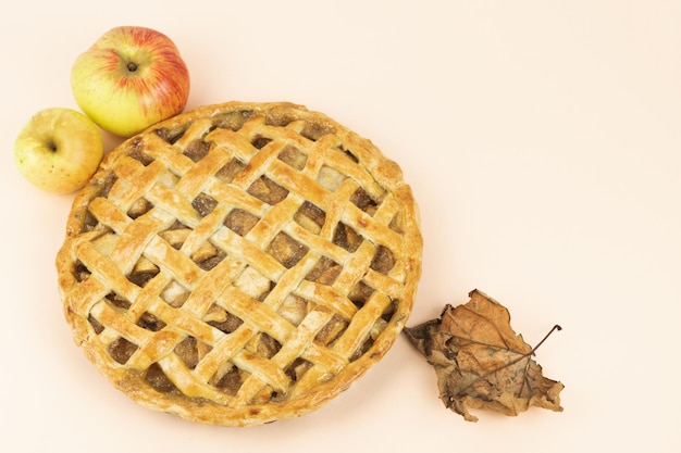 Baked apple pie with trellis decoration Apples and dried leaves Copy space