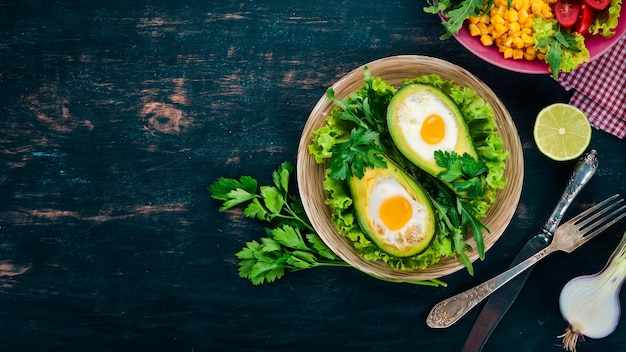 Baked avocado with egg Healthy food On a wooden background Top view Copy space