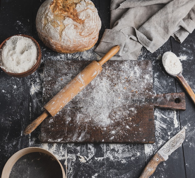 Baked bread, white wheat flour, wooden rolling pin 