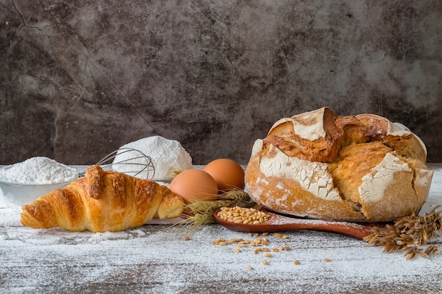 Baked bread with cereals placed on a wooden table.